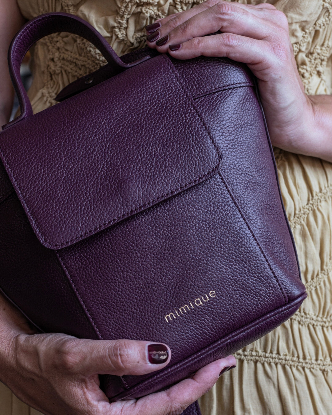 Bolso bandolera Andrín mini de Mimique en piel color burdeos. Con tapa, cremallera asa regulable