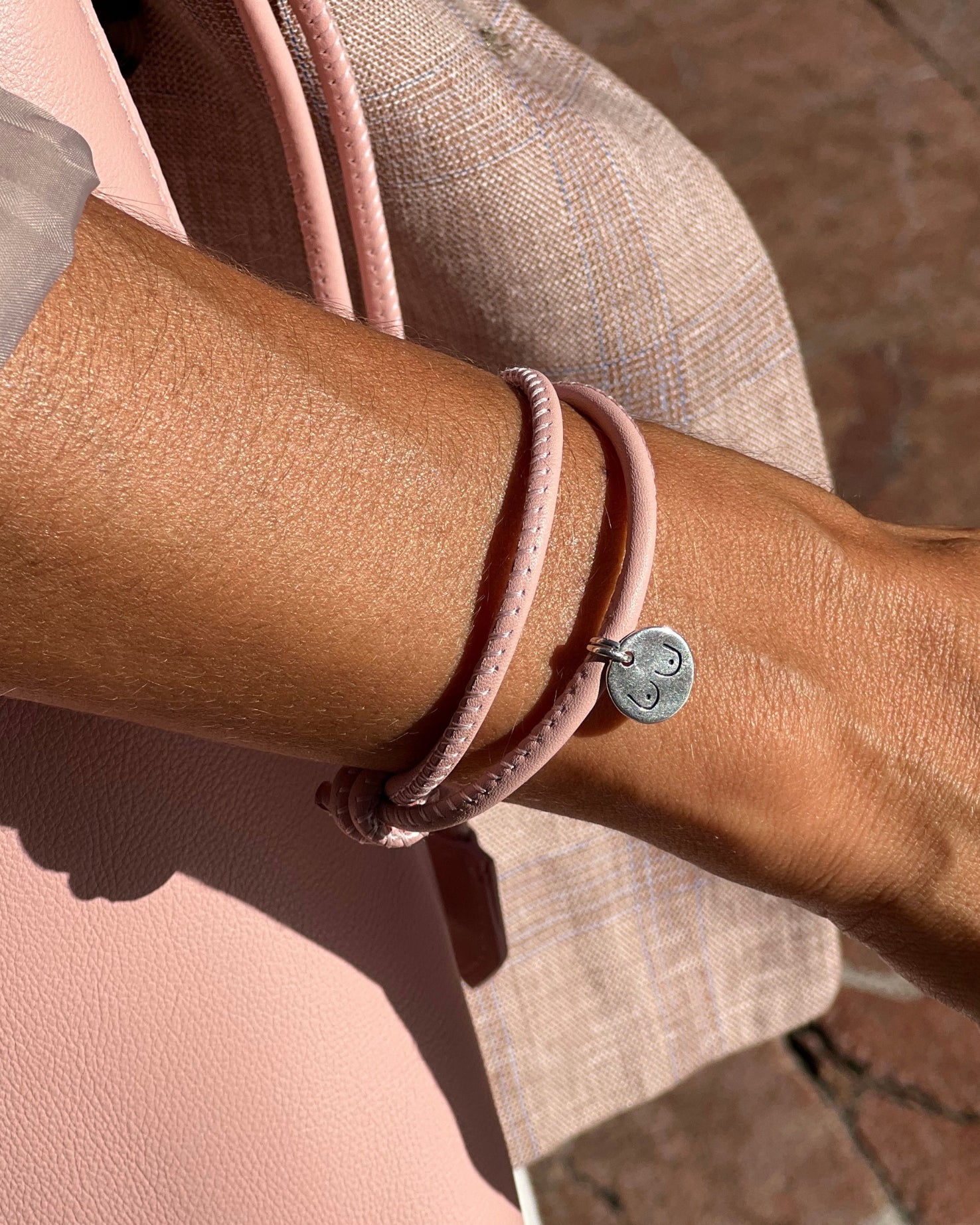 Pulsera solidaria de piel con medalla maquillaje
