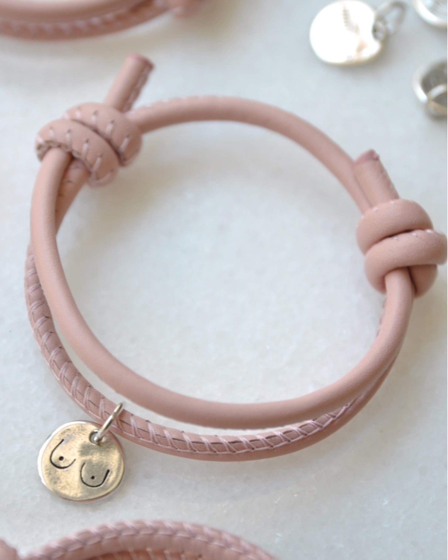 Pulsera solidaria de piel con medalla maquillaje