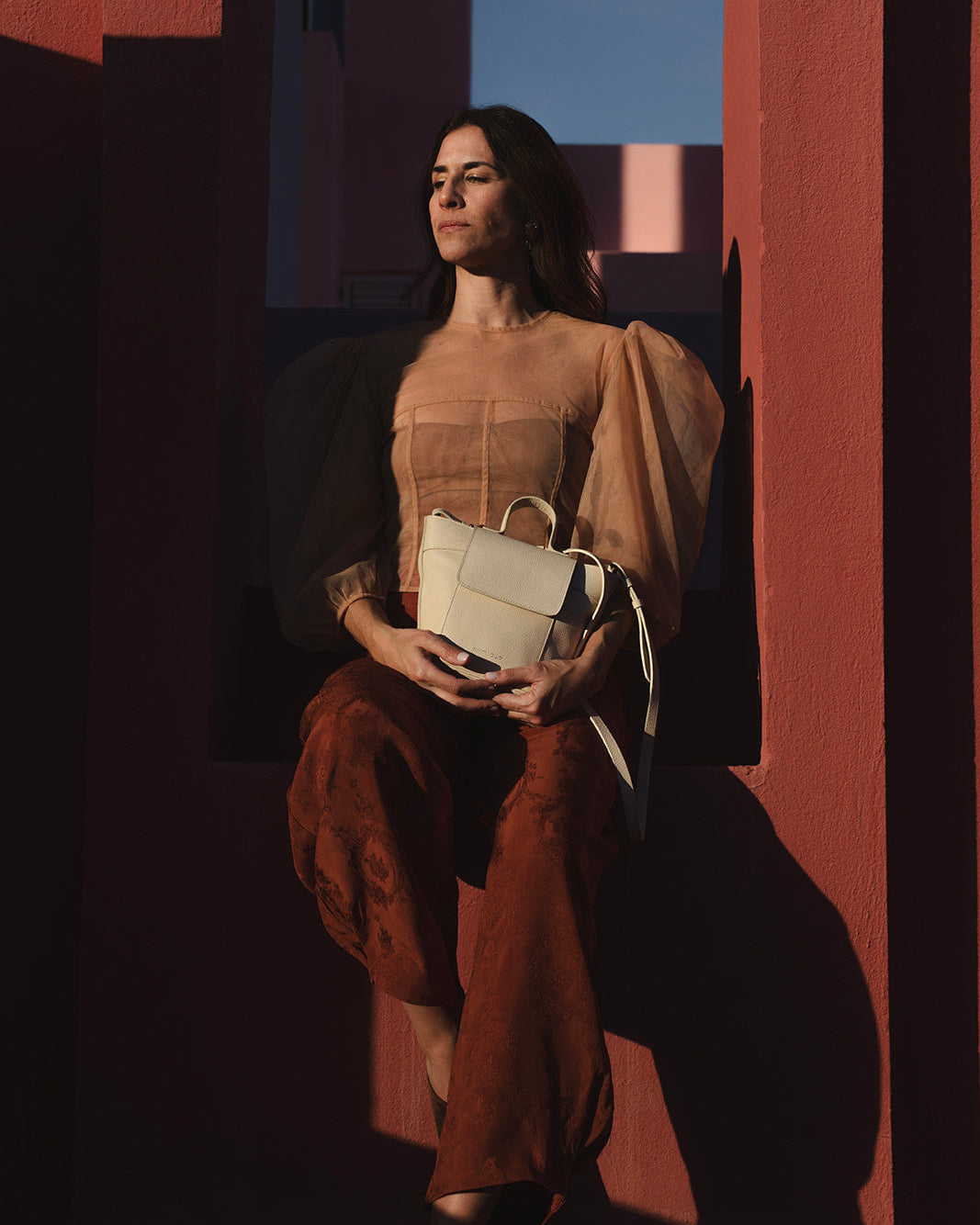 Bolso de piel para mujer Andrín Mini en color crema. Asa ajustable y cierre con cremallera y tapa. Fabricado en España