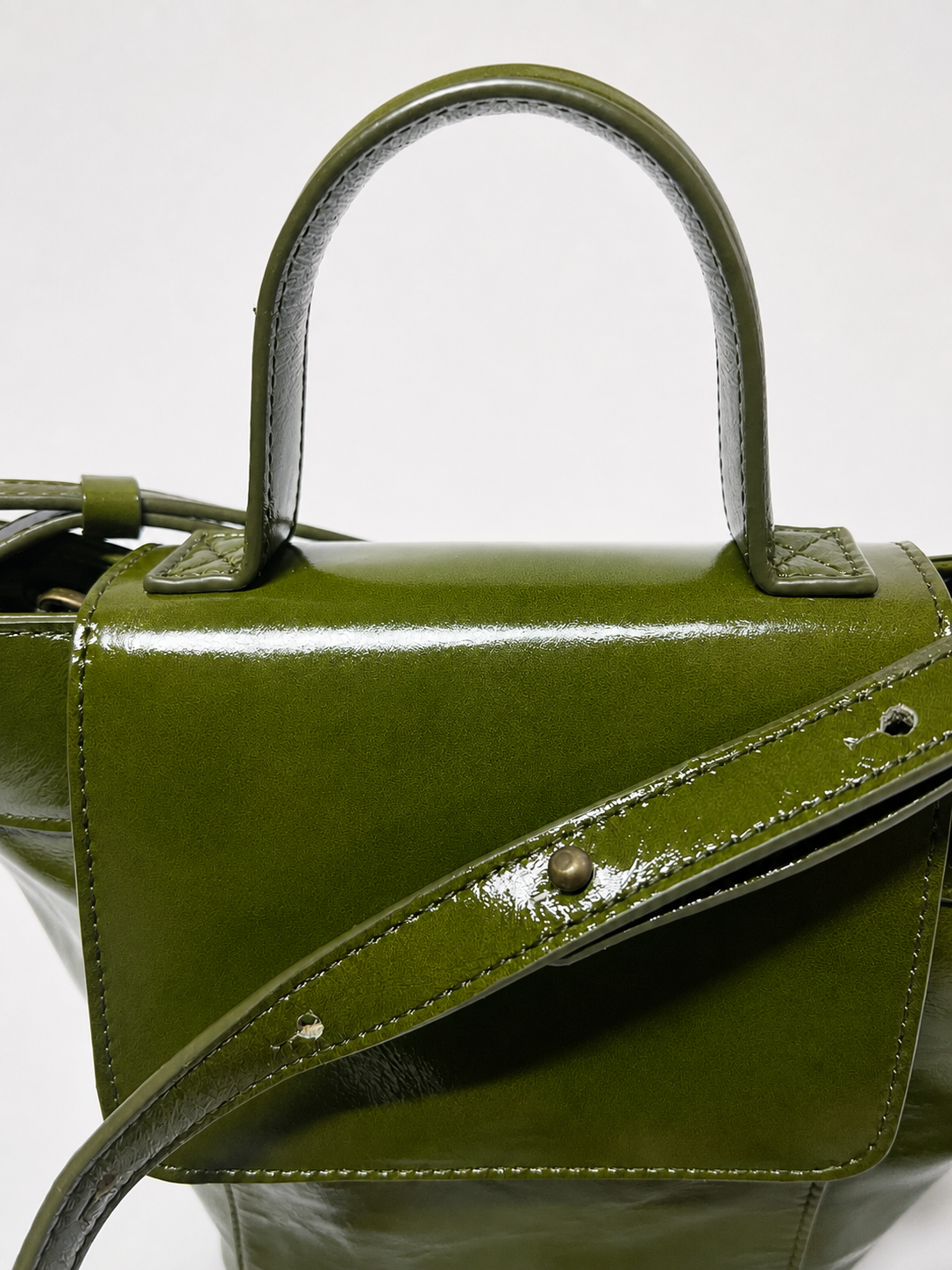 Andrín mini verde musgo en piel con brillo y acabado charol con asa bandolera regulable hecho en España