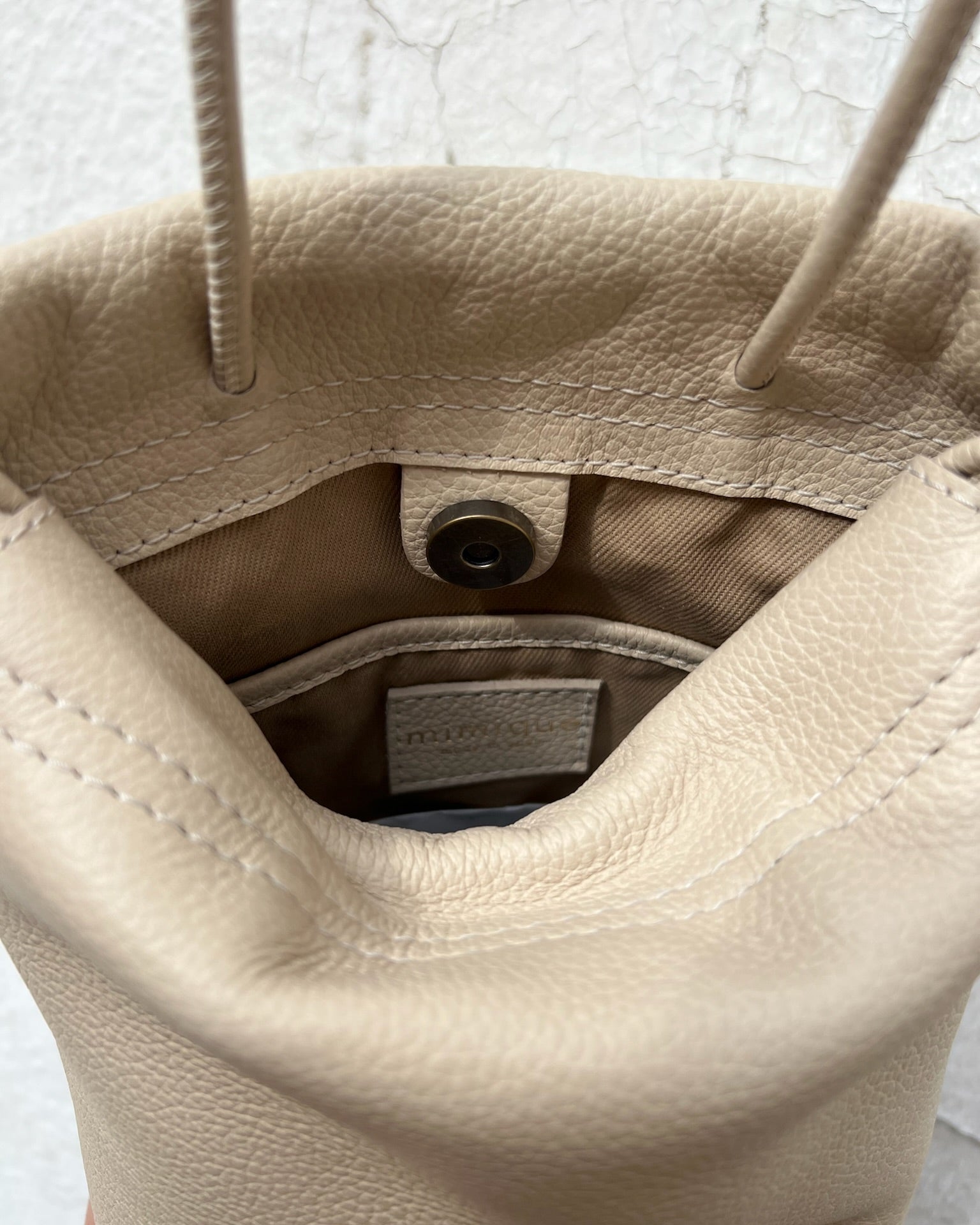 Bolso bombonera pequeño para mujer Cue color crema de Mimique. Piel y materiales de máxima calidad. Bandolera cómoda y con gran capacidad hecha a mano en España. Forro y bolsillo interior