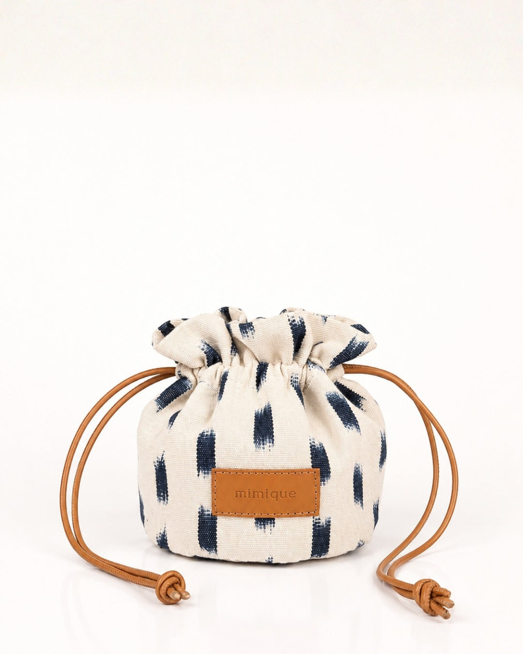 Mini bombonera artesanal ikat blanca y azul de Mimique para la playa con asa ajustable