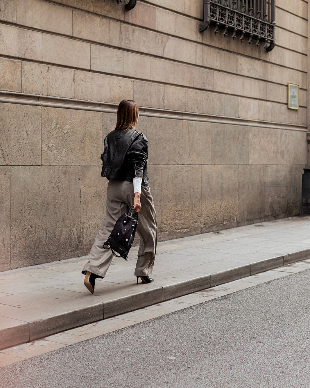 Mochila bolso de piel negra para mujer Tachuelas mini media bola de Mimique. Diseño versátil y atemporal. Hecha a mano en España.