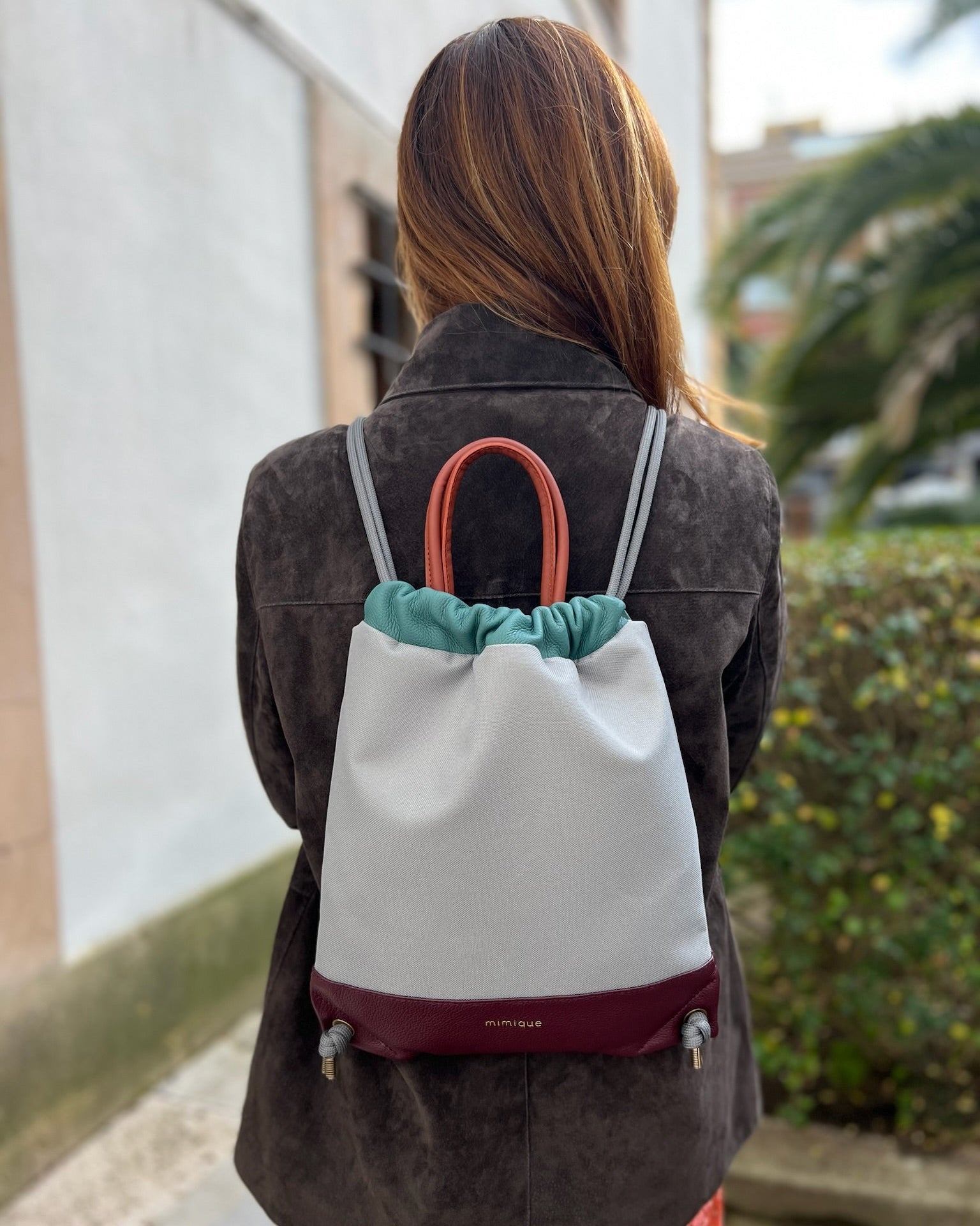Mochila bolso mujer Atalaya de Mimique en piel y loneta impermeable burdeos y gris, hecha a mano en España, ligera y con cierre seguro.