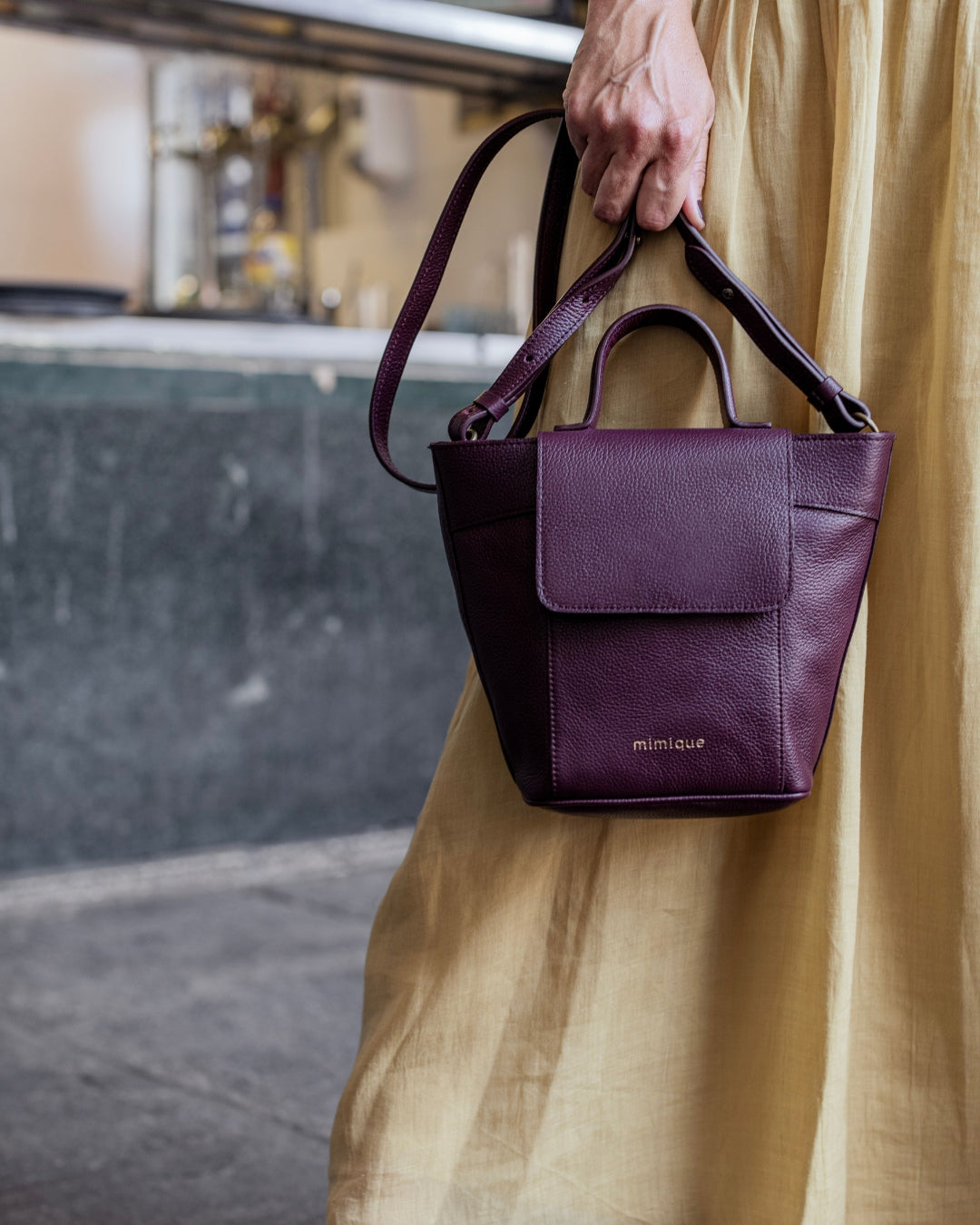 Bolso bandolera Andrín mini de Mimique en piel color burdeos. Con tapa, cremallera asa regulable