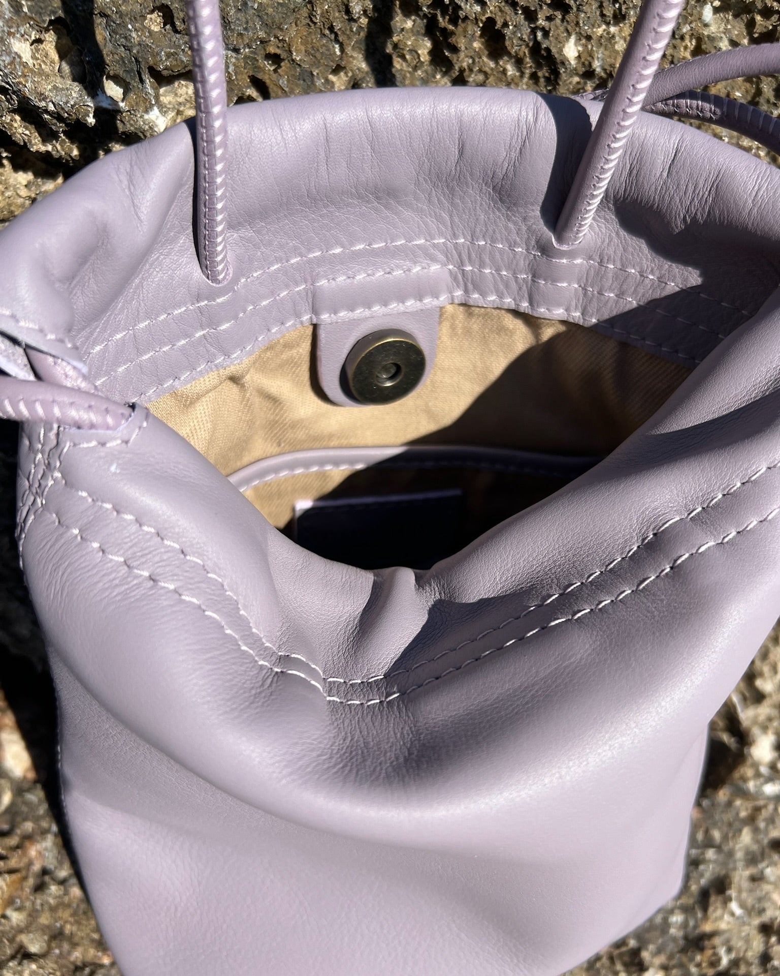 Mini bolso Cue de Mimique color lavanda para mujer en piel de máxima calidad. Bombonera de gran capacidad y forro y bolsillo interior Made in Spain
