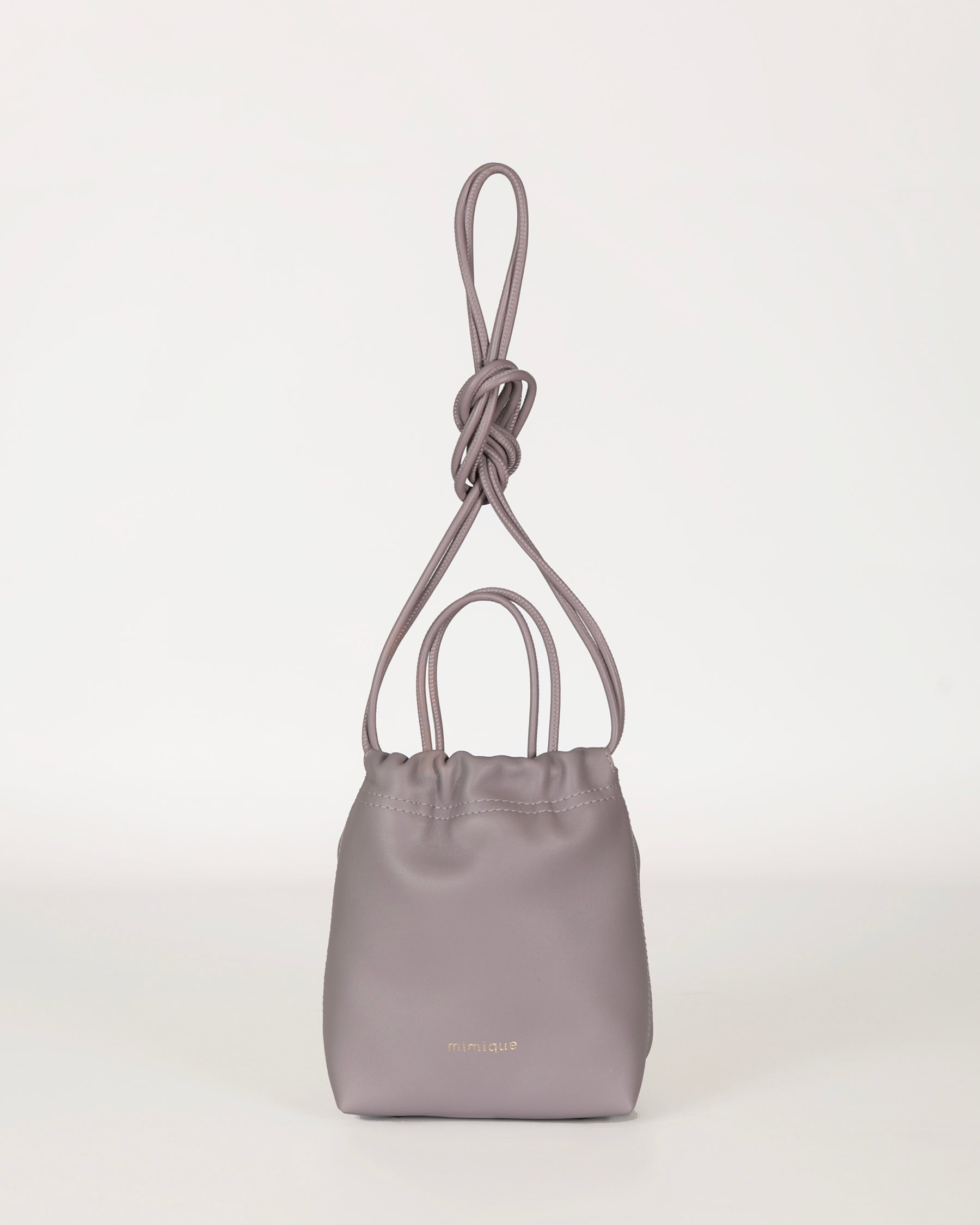 Bolso bandolera Cue color morado lila lavanda para mujer en piel de gran calidad. Diseño de bombonera con asa de mano. Hecho en España - Mimique