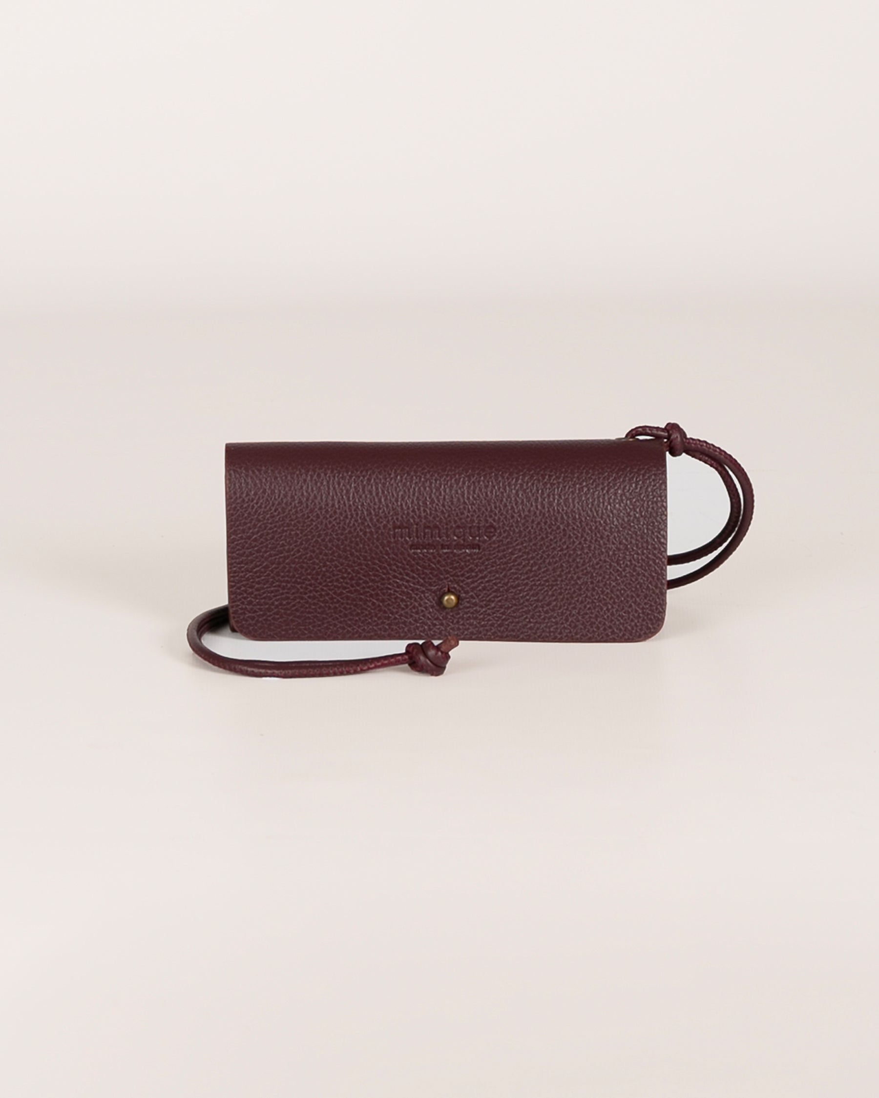 Funda de gafas de piel color burdeos de Mimique. Hecha a mano en España en piel de la mejor calidad con un diseño único y original. Lleva un cordón de piel poder colgarla. Entran todas las gafas.