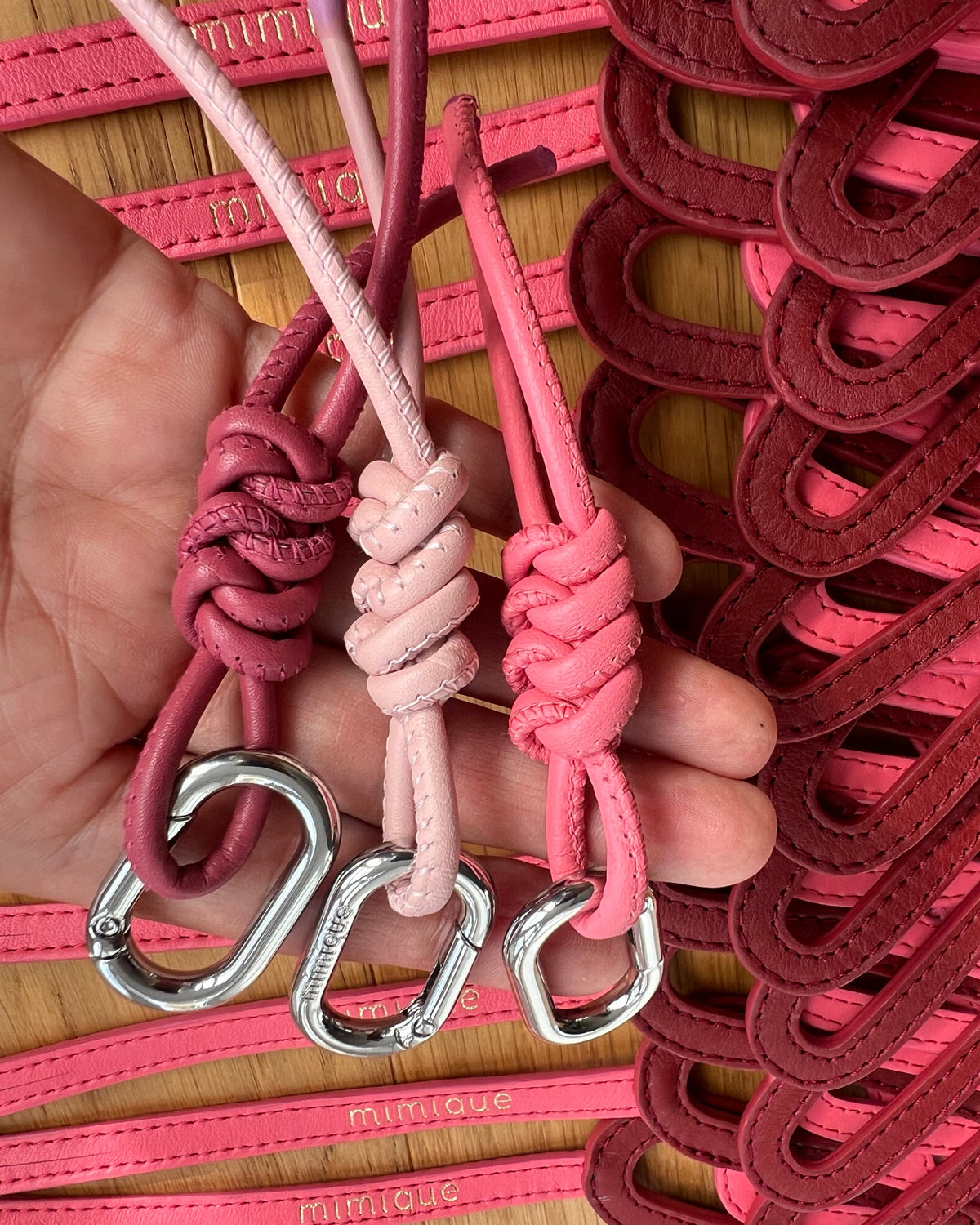 Llaveros solidarios de piel rosa Mimique con nudo de espiga y diseño de lazo lucha contra el cáncer de mama made in Spain