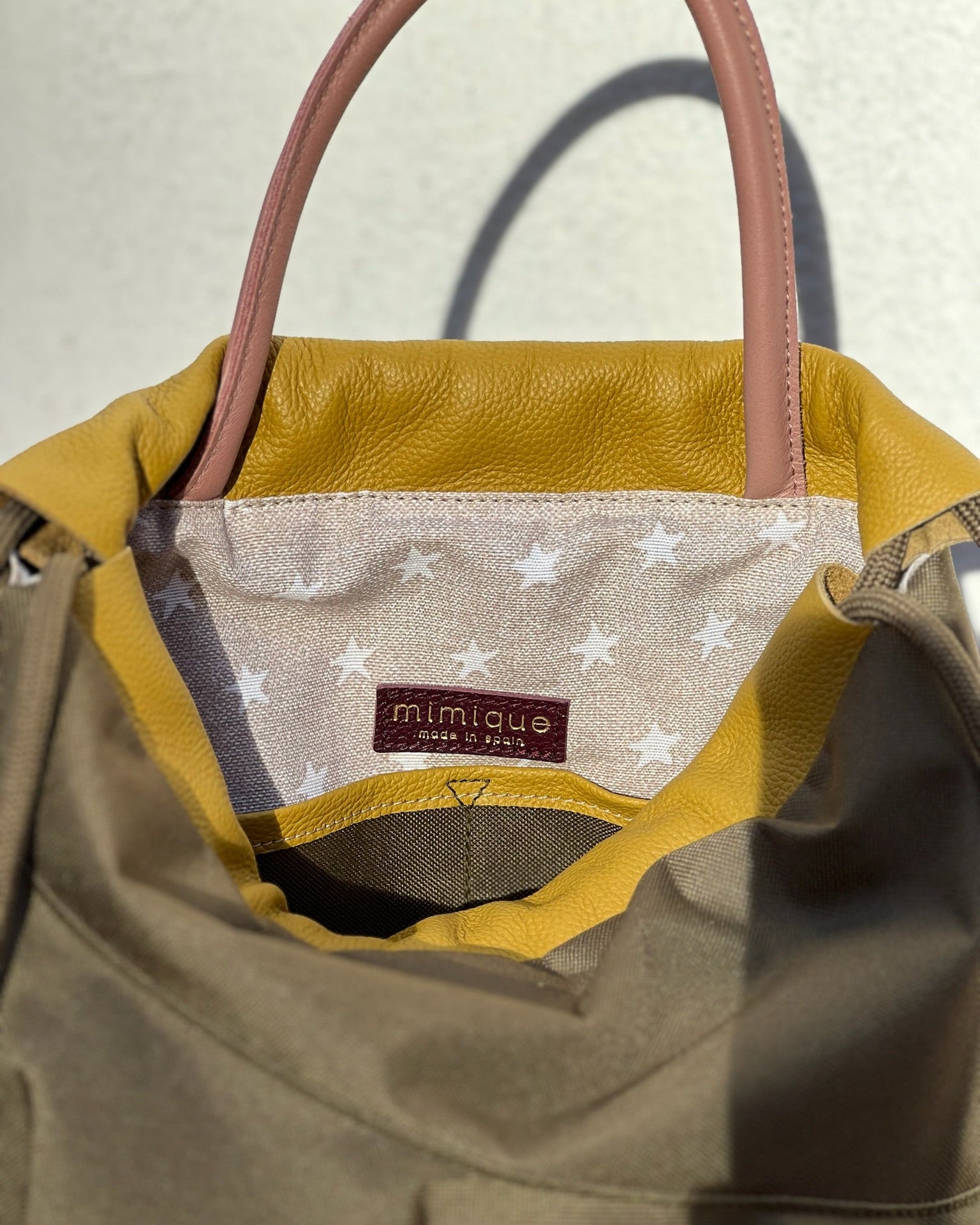 Mochila bolso de mujer de piel y loneta impermeable verde caqui y burdeos Zahora mini de Mimique. Diseño artesanal hecho en España. Cierre seguro 