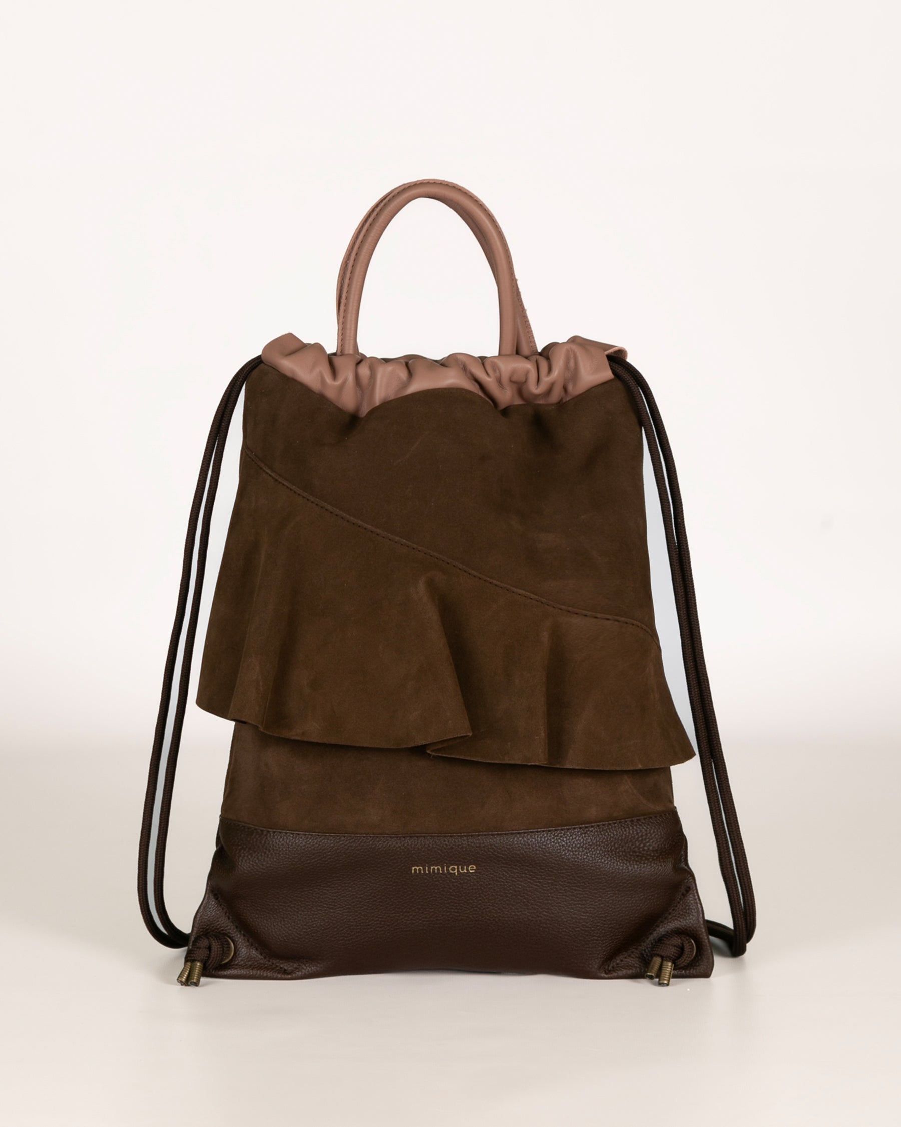 Mochila de piel y serraje marrón chocolate y rosa de Mimique. Tamaño grande con original diseño con volante. Hecha de forma artesanal en España con materiales de gran calidad. Cómoda, ligera y con gran capacidad